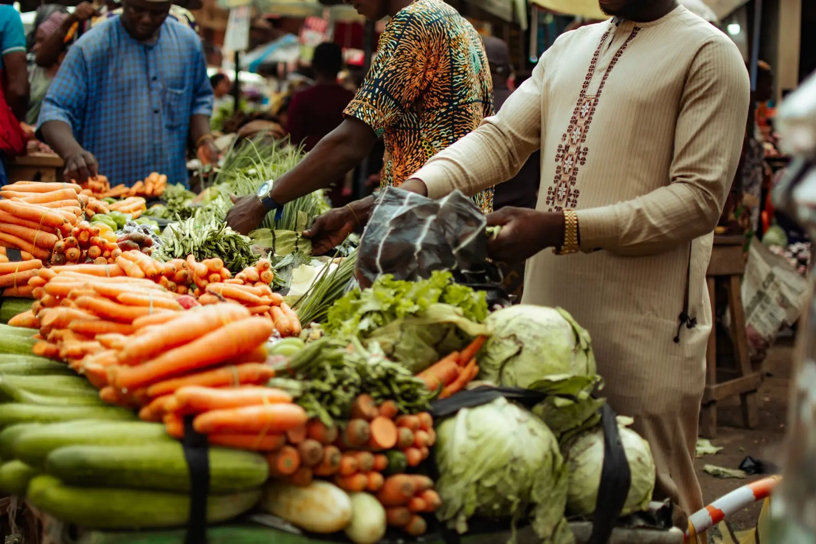 Clients faisant leurs achats parmi des légumes frais au marché — photo d’illustration (banque d’images)