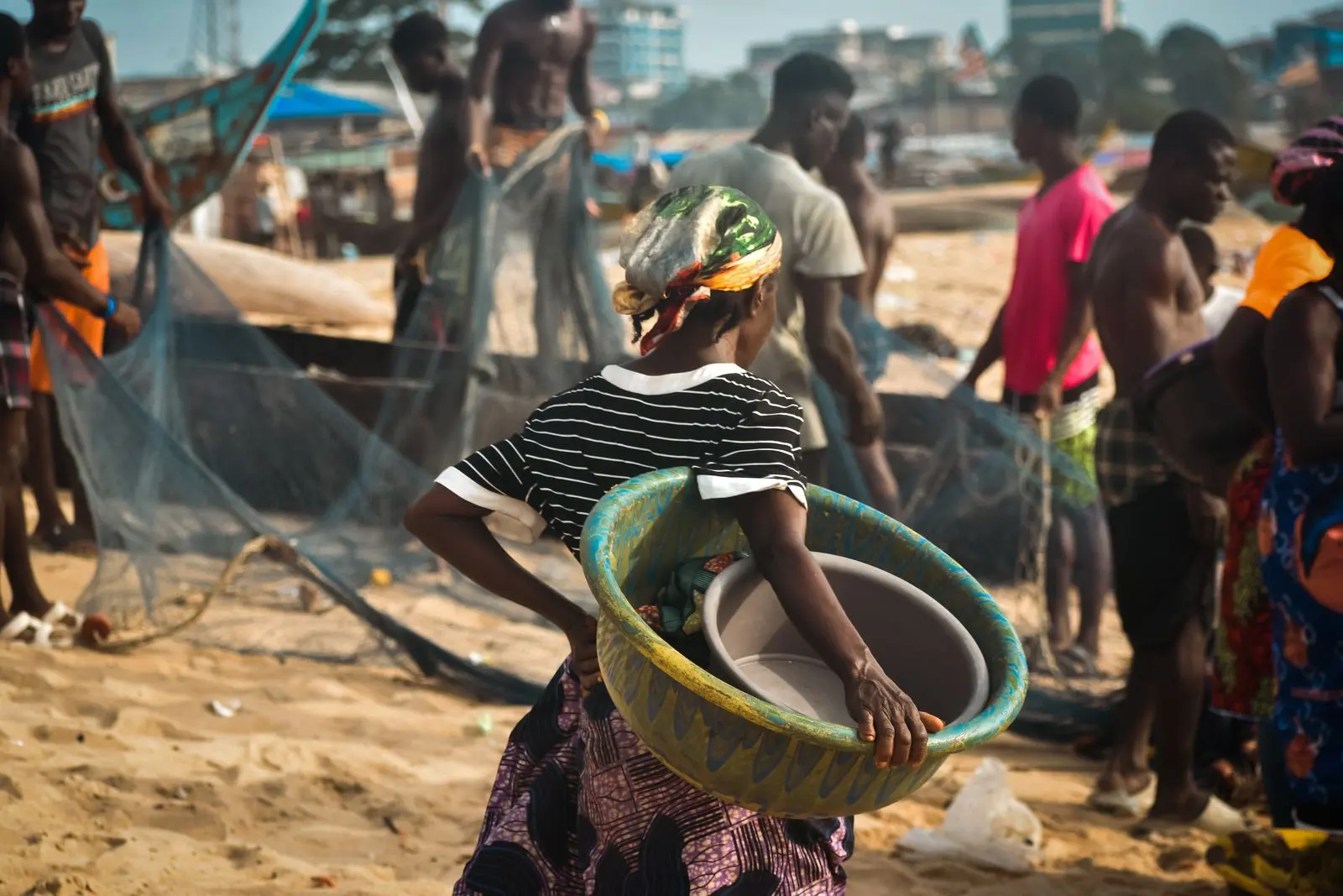 Vendeuse transporte un panier près d’un marché côtier — photo d’illustration (banque d’images)