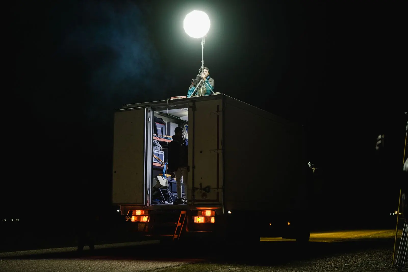 Équipe de tournage travaillant de nuit avec un camion-éclairage — photo d’illustration (banque d’images)