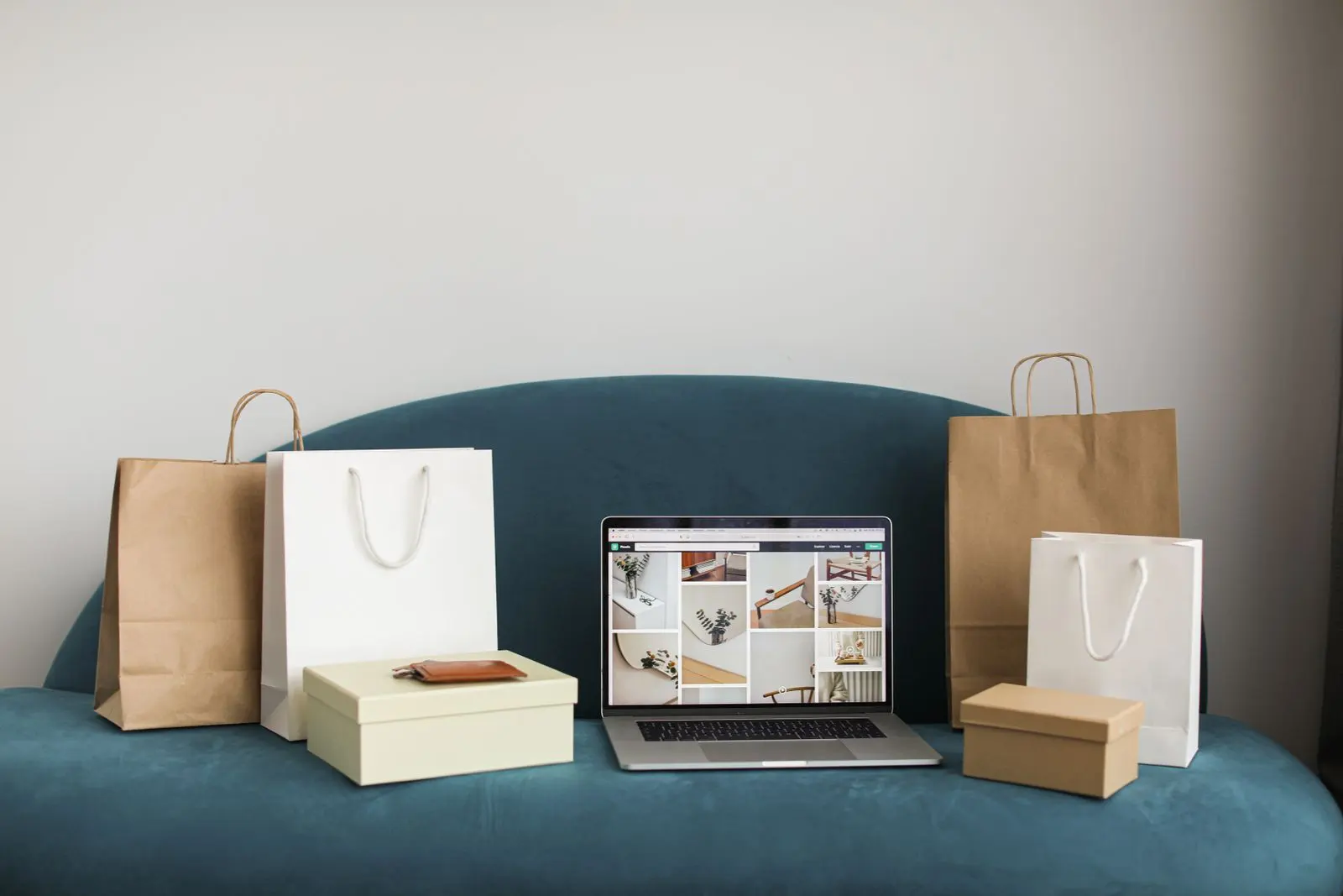 Ordinateur entouré de sacs et colis pour achats en ligne — photo d’illustration (banque d’images)