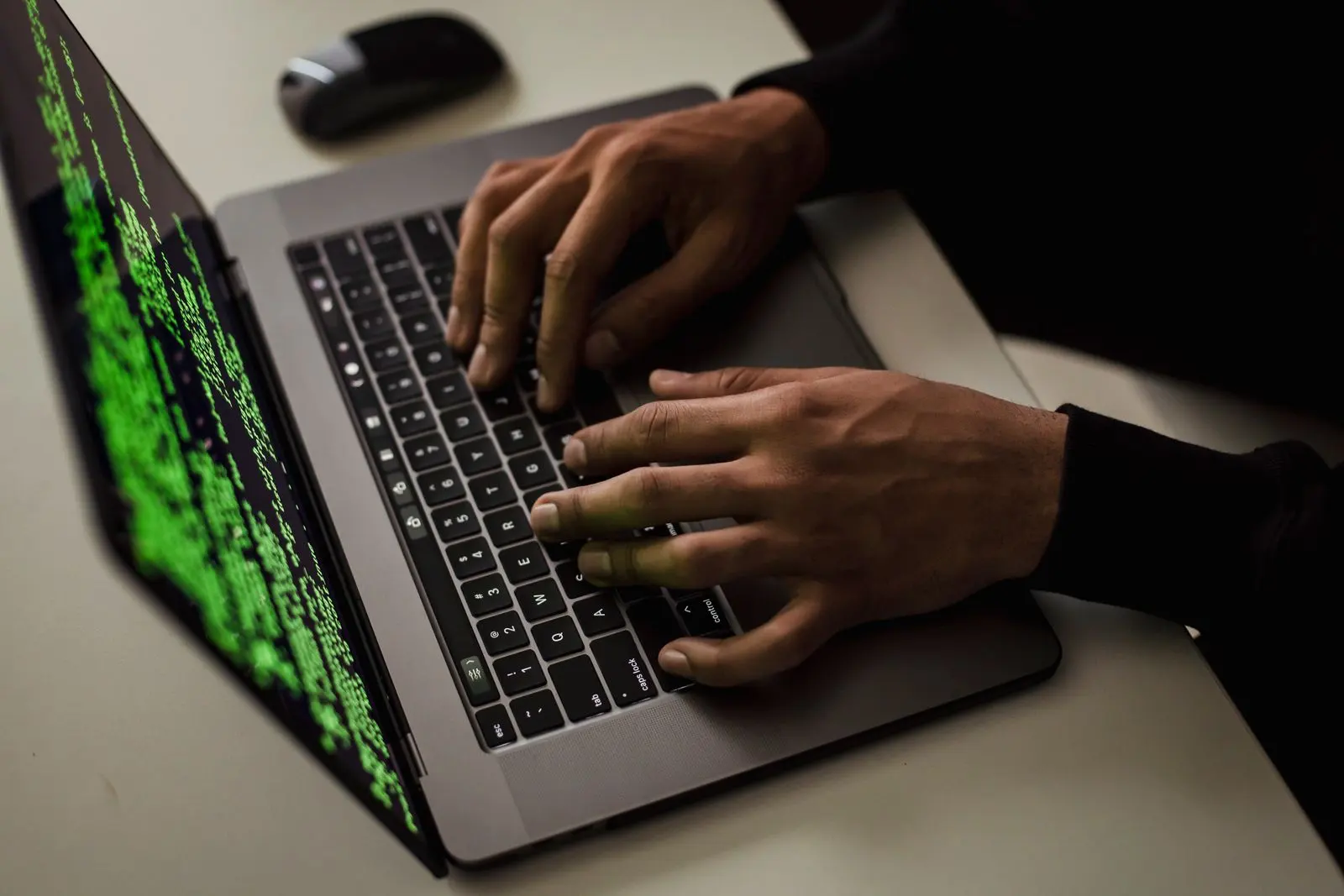 Mains d’un analyste tapant sur un ordinateur affichant du code — photo d’illustration (banque d’images)