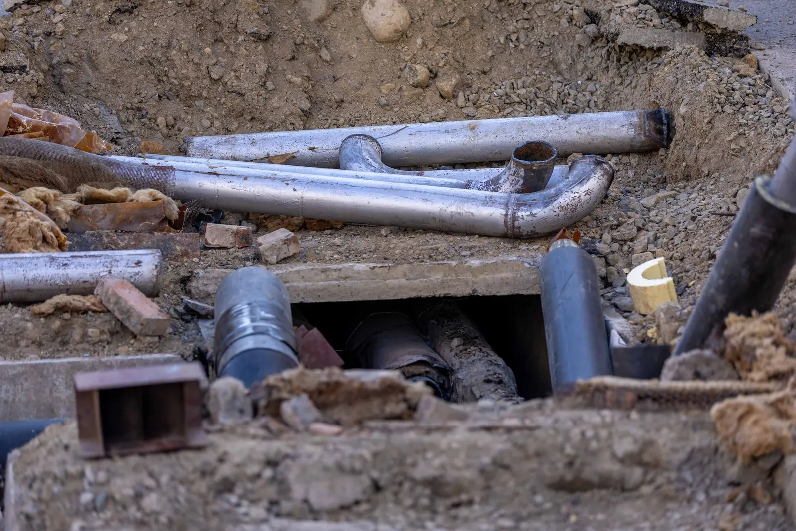 Tuyaux installés dans une tranchée de chantier urbain — photo d’illustration (banque d’images)
