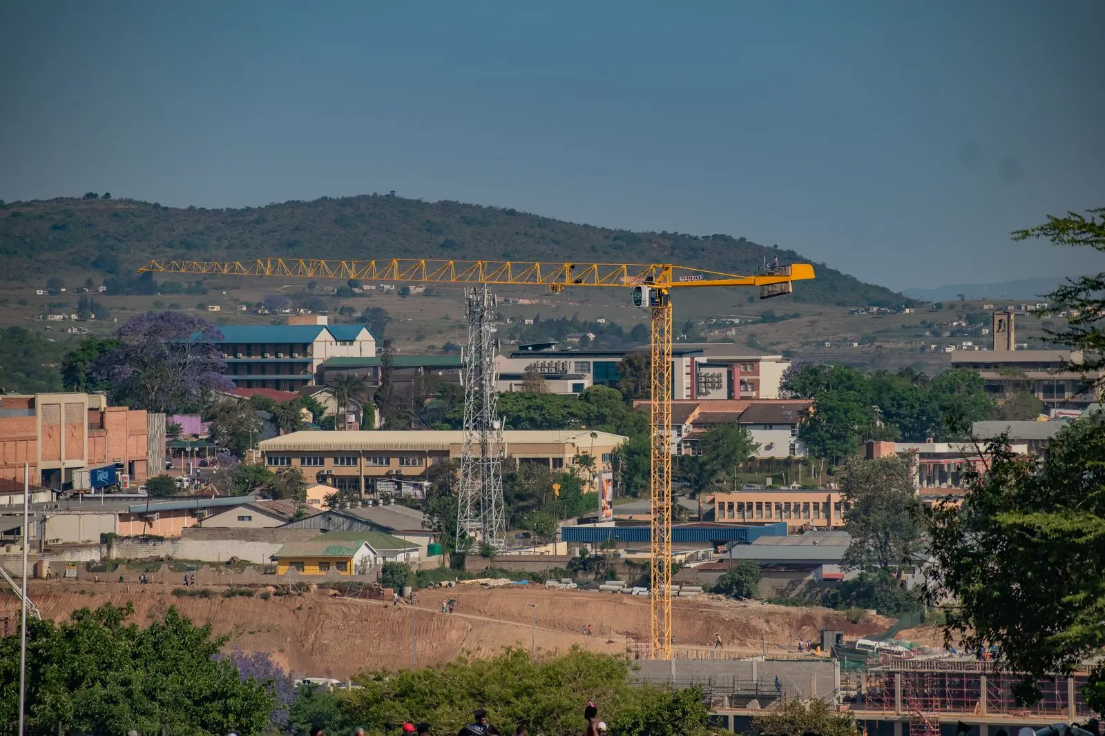 Vue urbaine de Manzini avec chantiers et grues — photo d’illustration (banque d’images)