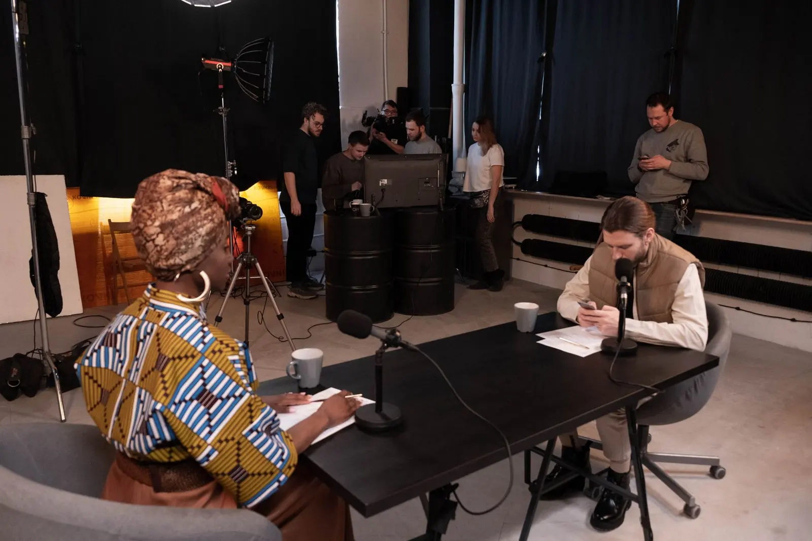 Équipe de journalistes en studio autour de micros — photo d’illustration (banque d’images)