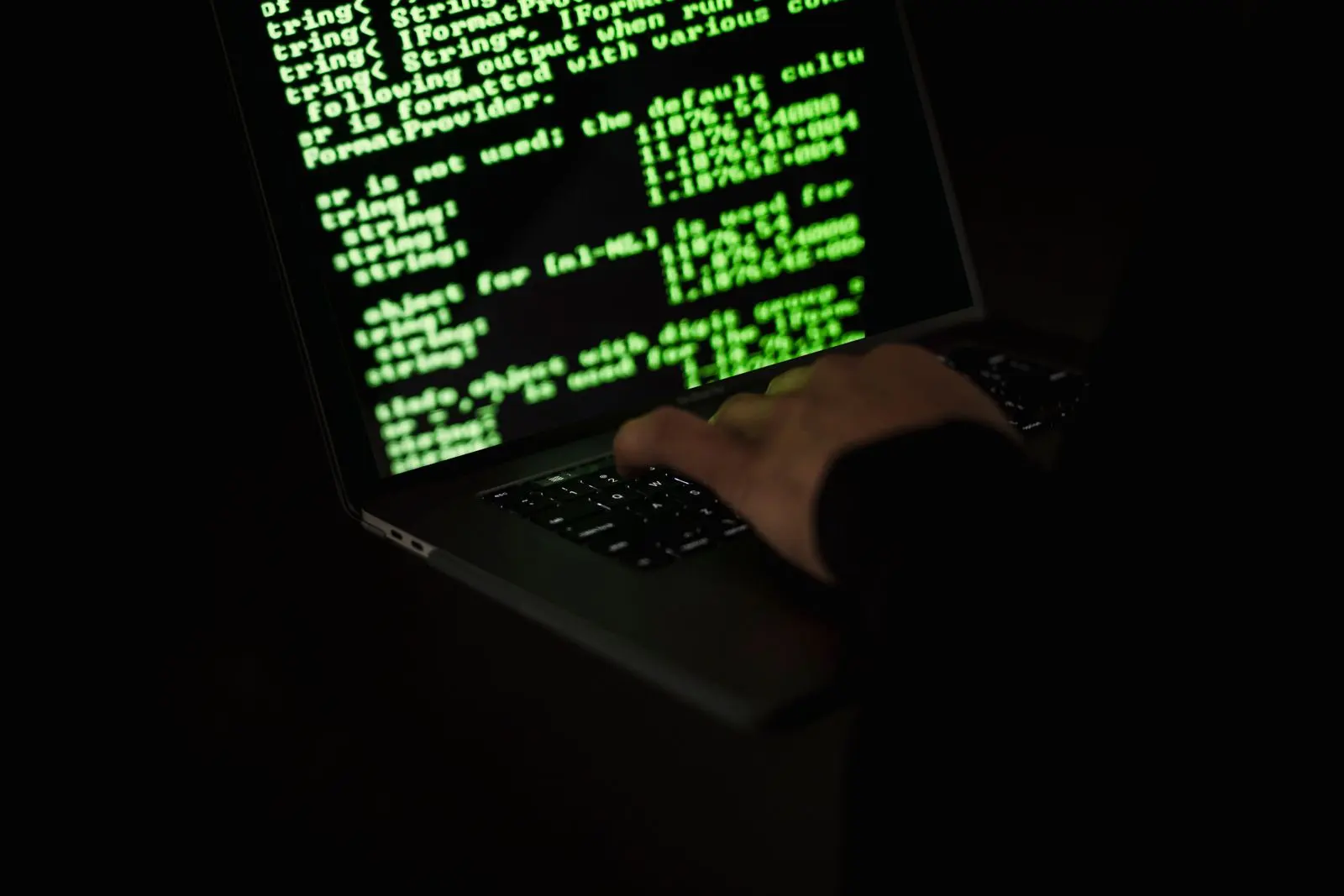 Main anonyme tapant du code sur un ordinateur portable — photo d’illustration (banque d’images)