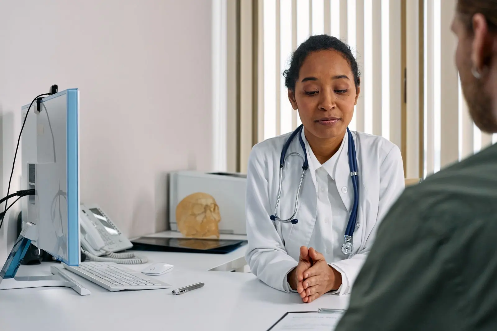 Médecin africaine consultant un patient dans un cabinet médical — photo d’illustration (banque d’images)