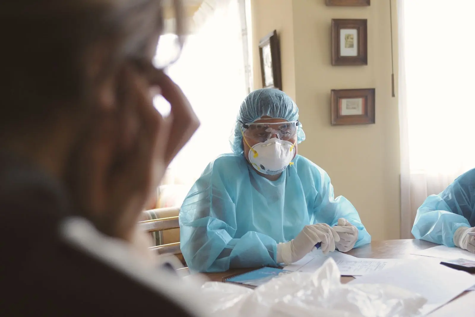 Soignante en équipement de protection lors d’une consultation médicale — photo d’illustration (banque d’images)