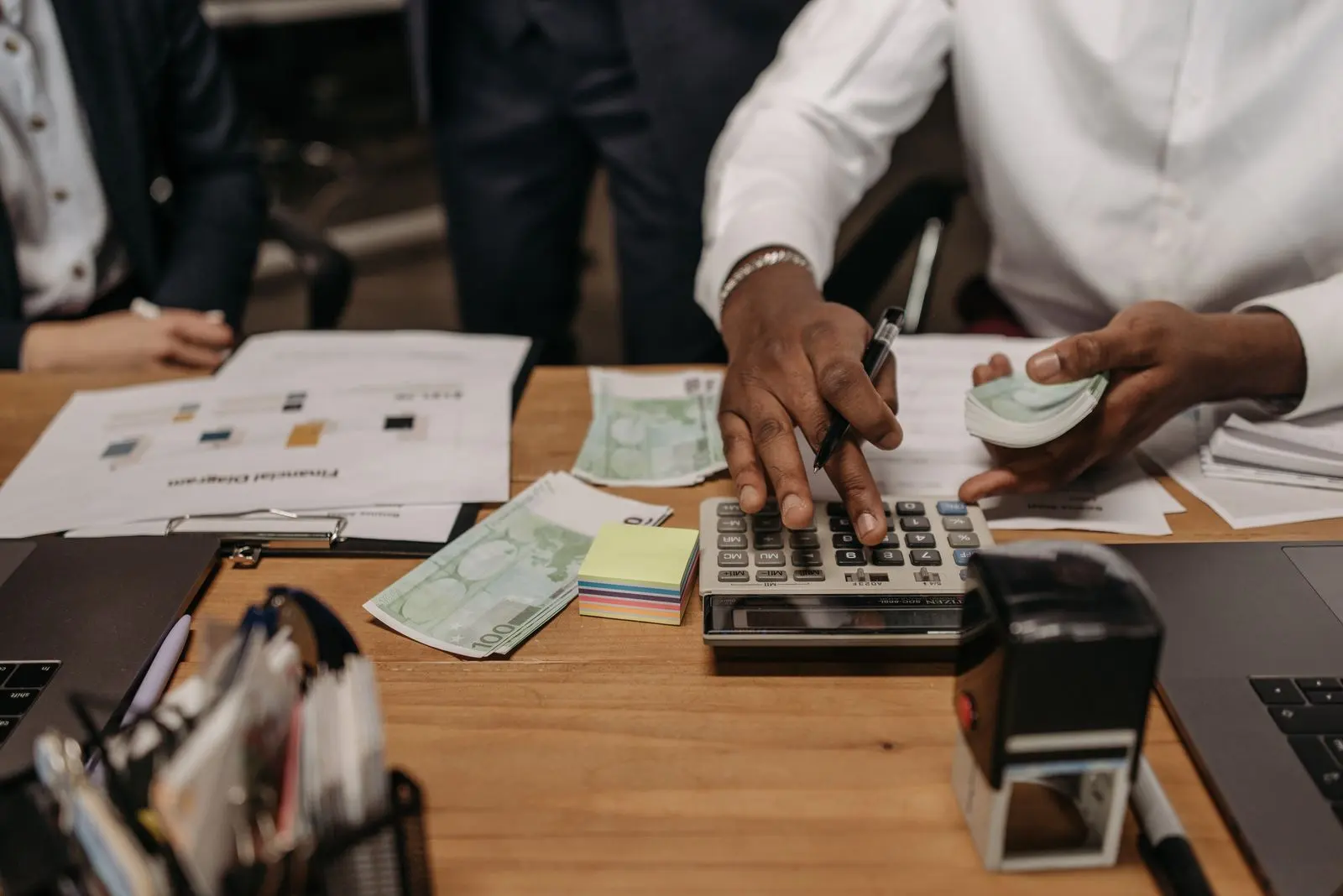 Des personnes calculent un budget autour de documents financiers — photo d’illustration (banque d’images)