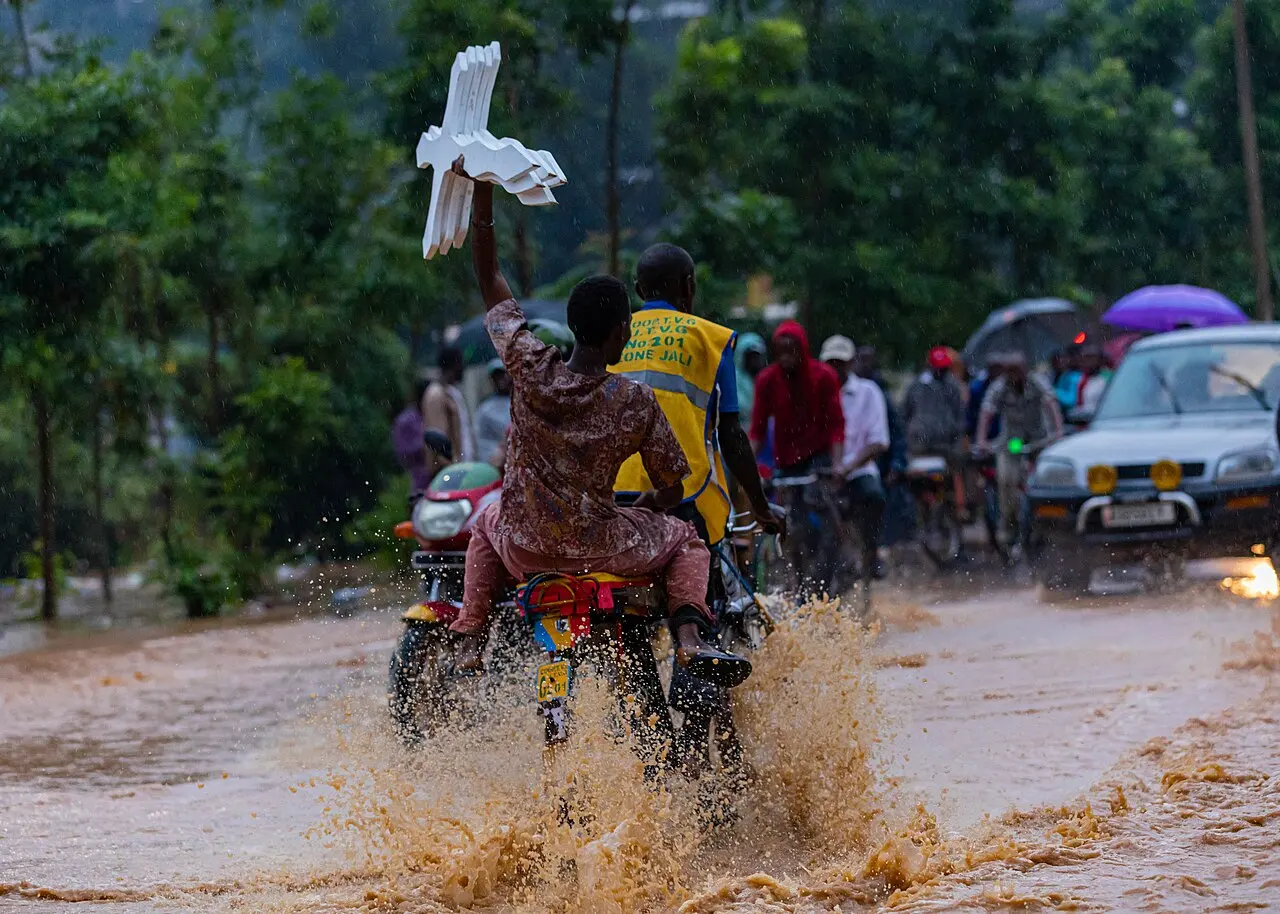 A bicycle rider carrying a passenger with crosses hustles his way through a flooded road in Kigali on 28 January 2020. Emmanuel Kwizera — photo d’illustration (inondations)
