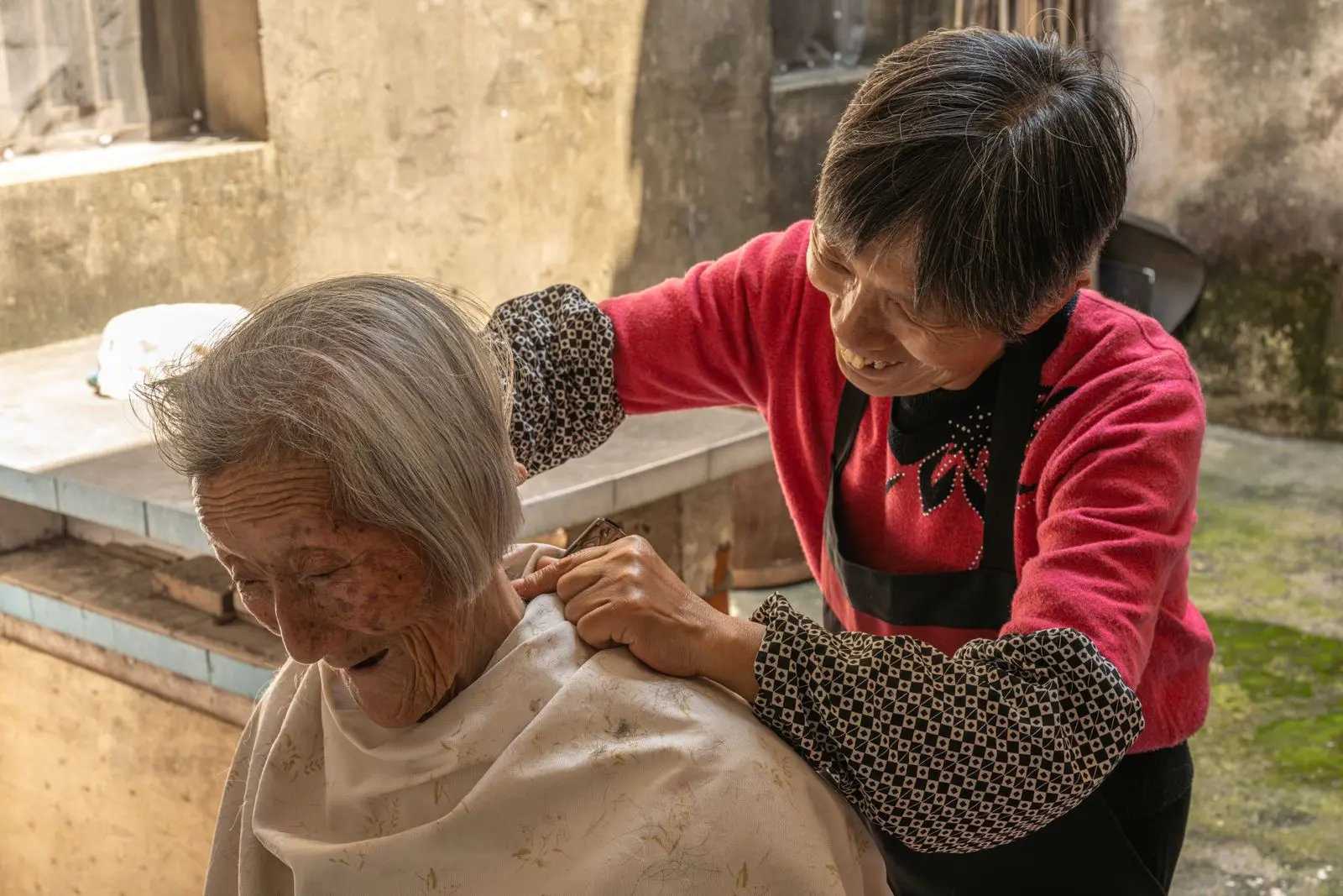 Une femme chinoise aide une personne âgée à se faire coiffer — photo d’illustration (banque d’images)